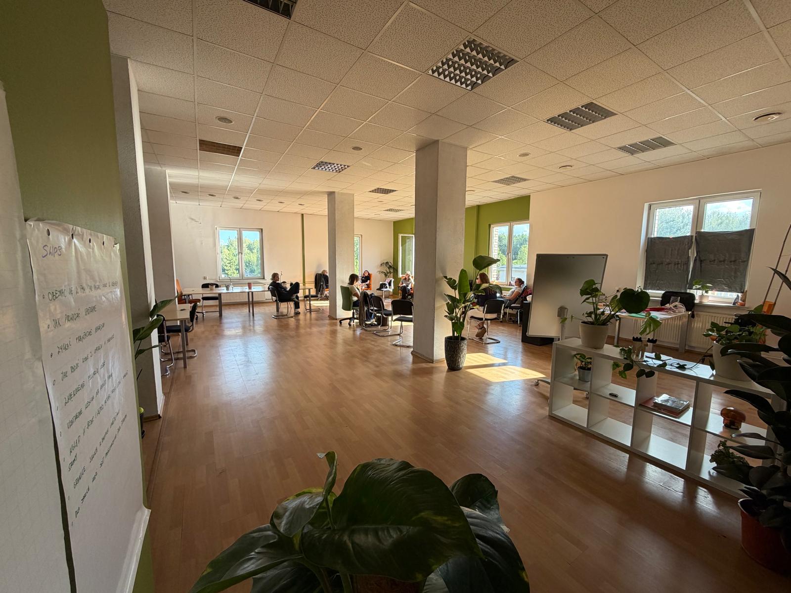 Sala coworkingu w Katowicach z tablicą flipchart, miejscem do pracy i spotkań w postindustrialnej fabryce.